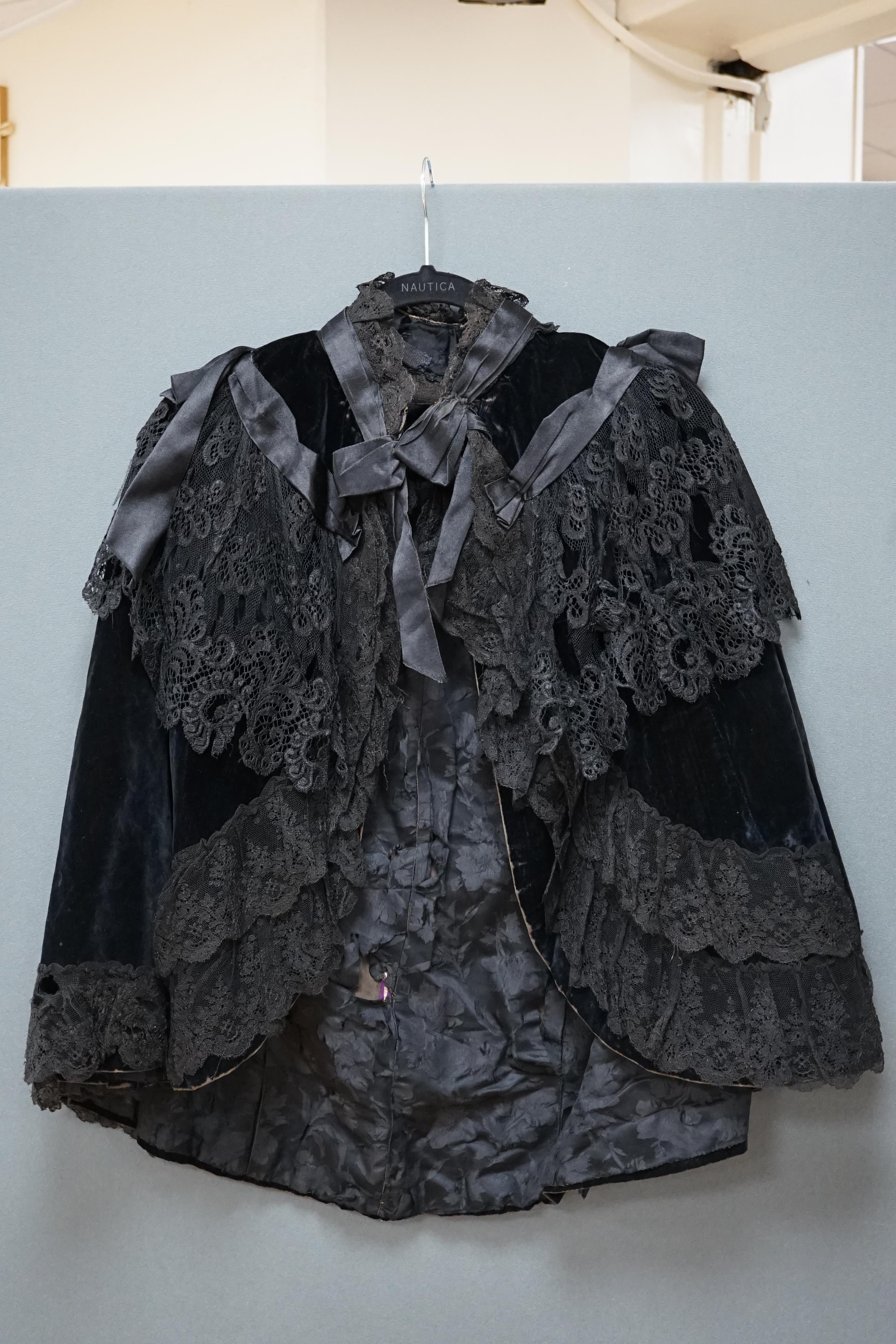 An Edwardian black velvet and black lace evening cape together with a purple chiffon and cream lined blouse labelled John Barker and Co, blouse specialists, Kensington, cape back, neck to bottom edge 72cm. Condition - th